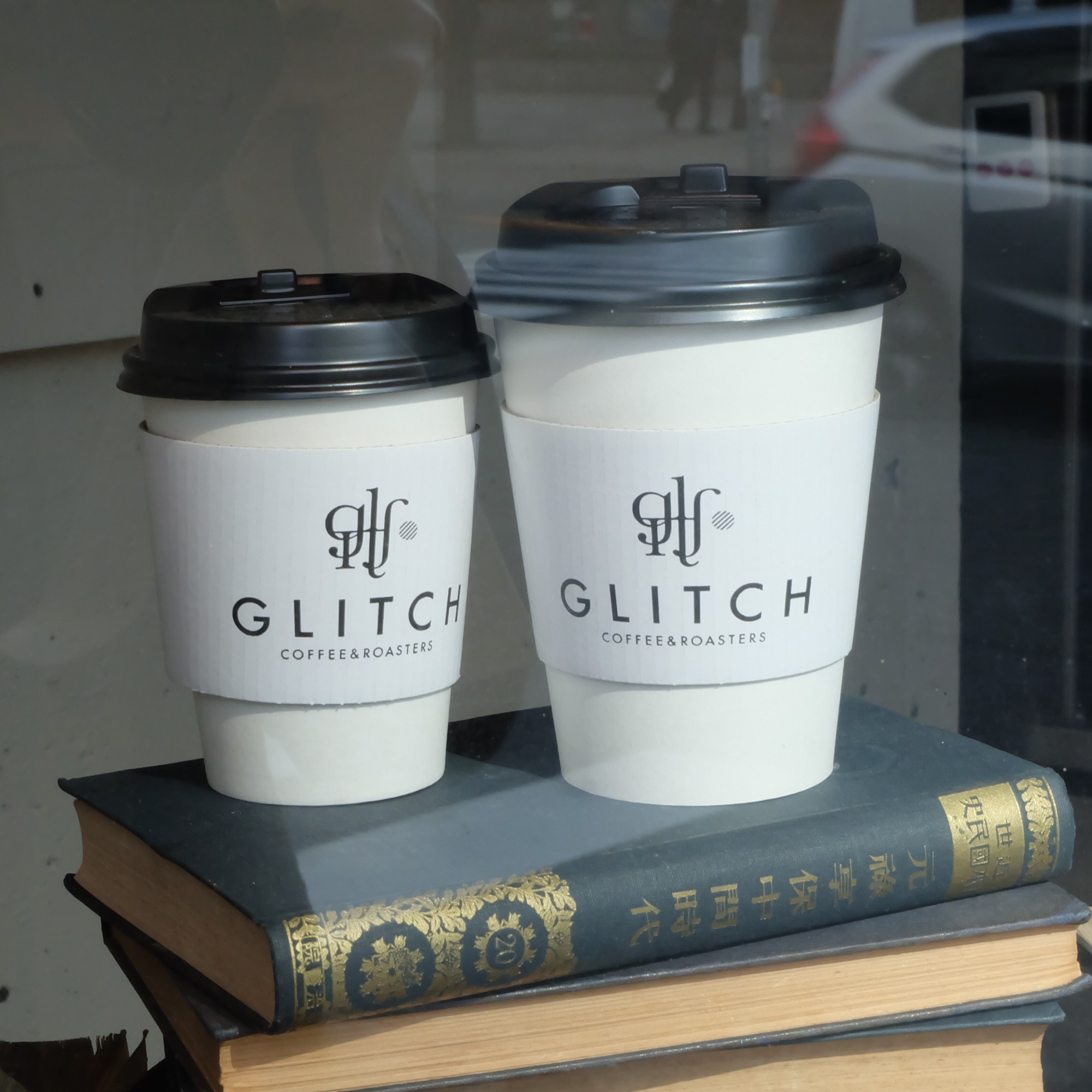 Paper coffee cups on Japanese book at Glitch Coffee and Roasters in Jimbocho Tokyo Japan