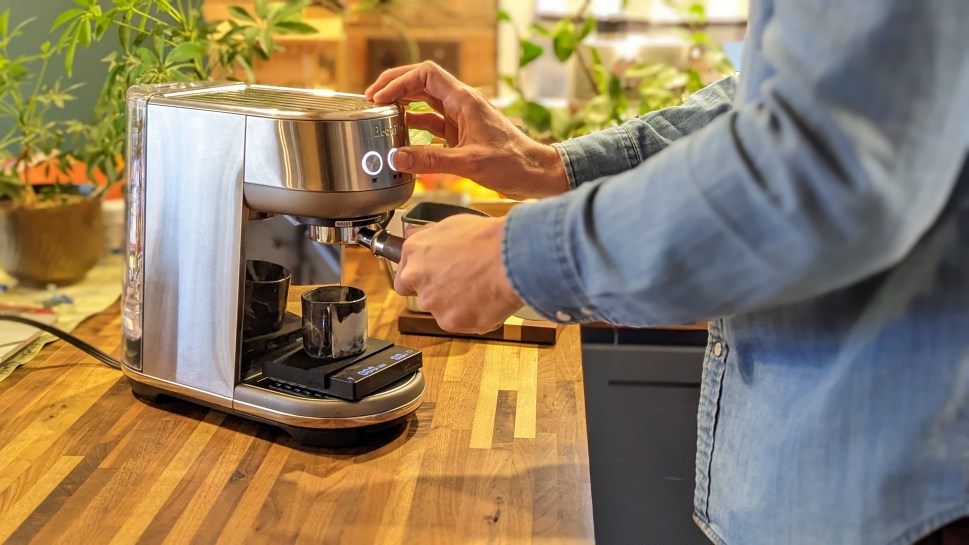 Barista making espresso using a breville bambino